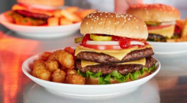 double beef burger on plate with tater tots