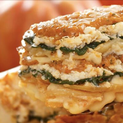 a square slice of casserole being lifted from a dish