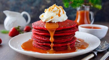 red velvet pancakes with whip cream and caramel syrup