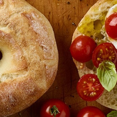 baguette bagel with tomatoes, fresh mozzarella and basil