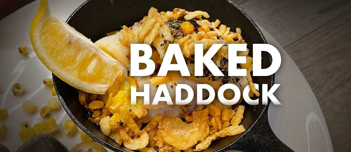 mini sized skillet with baked haddock and lemon slice. Words Baked Haddock over food