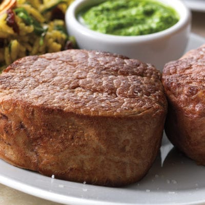 cooked beef tenderloins with rice and pesto sauce in ramekin