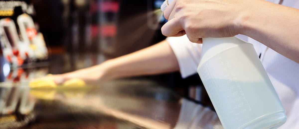 hands with spray bottle washing counter