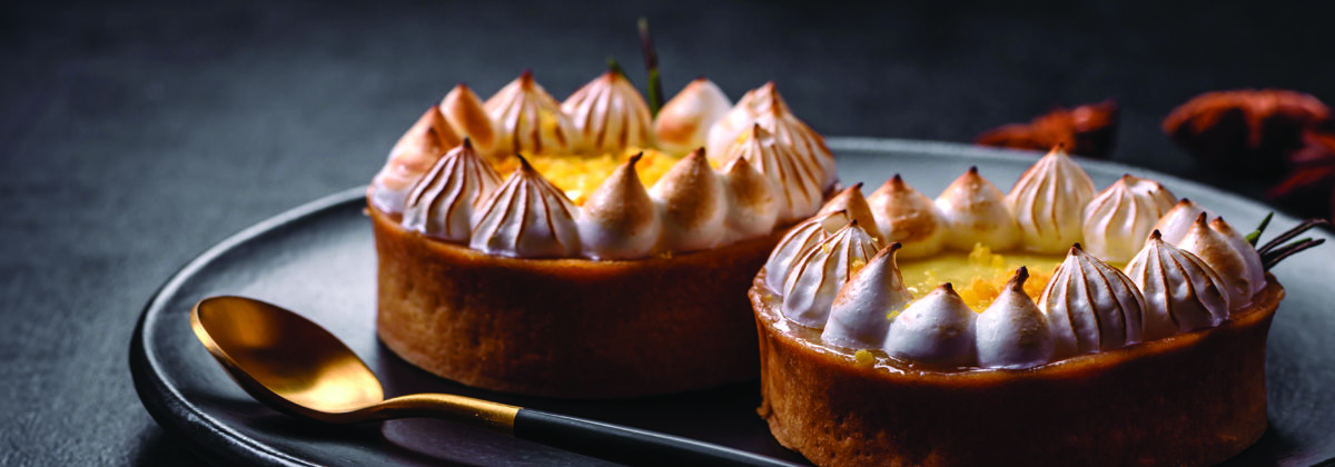 Black plate with two lemon tartlets