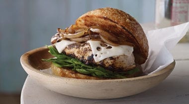 chicken breast sandwich with swiss cheese, spinach and grilled onions