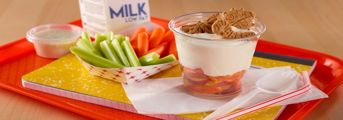 fruit parfait with celery and carrots on school tray