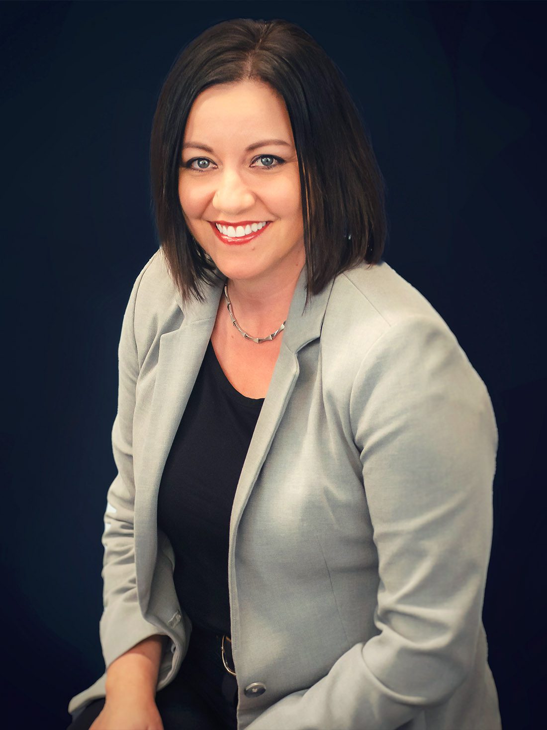 woman in tan suit smiling