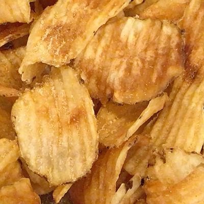 fresh fried crinkle chips on a black plate with dipping sauce