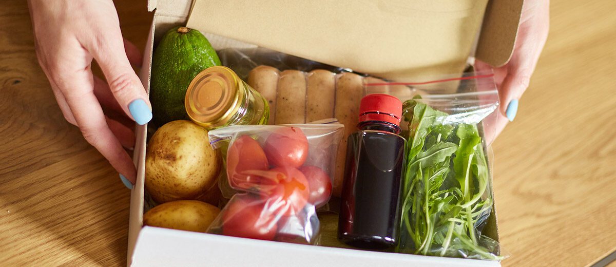 hands holding box of food ingredients