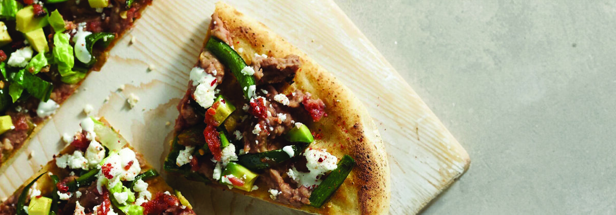 Mexican style flatbread pizza on wood platter