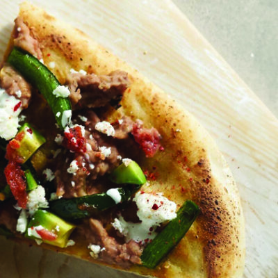 Mexican style flatbread pizza on wood platter