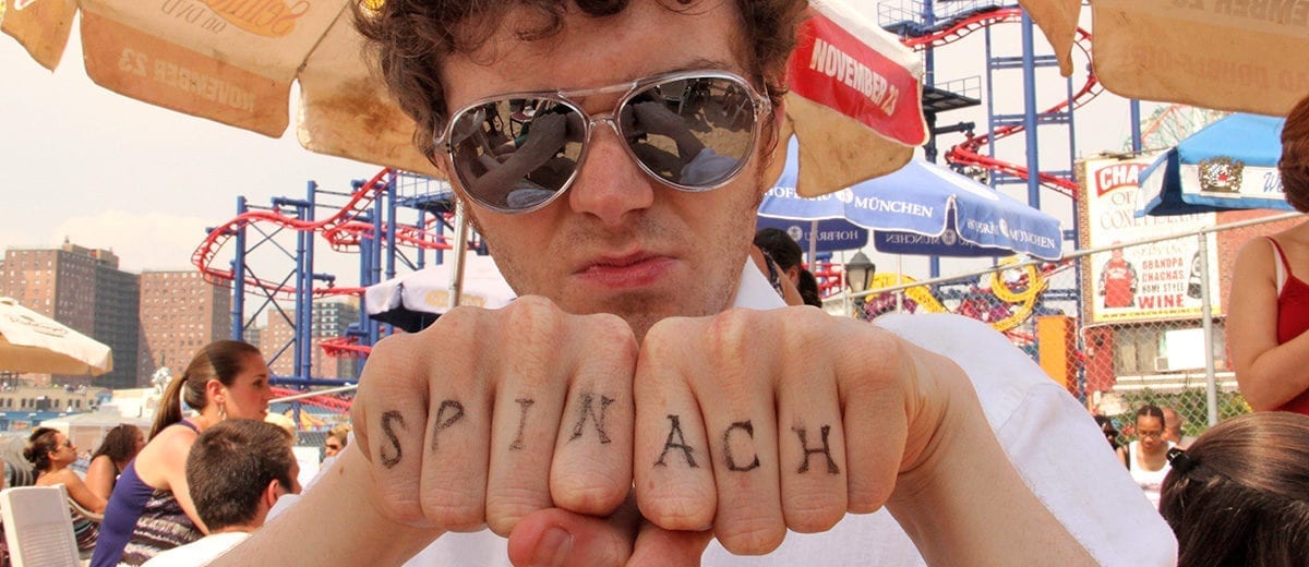 man with spinach written across his knuckles