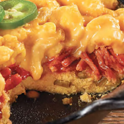 Stuffed Mac-n-cheese tart in cast iron skillet on wooden table