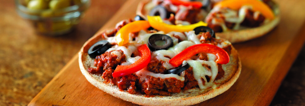 small personal beef pizzas on wood board on wood table