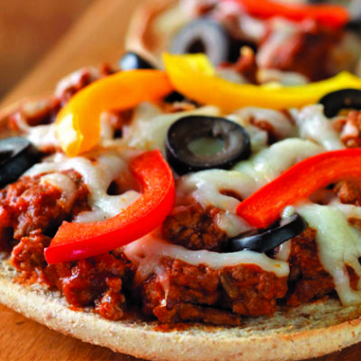 small personal beef pizzas on wood board on wood table