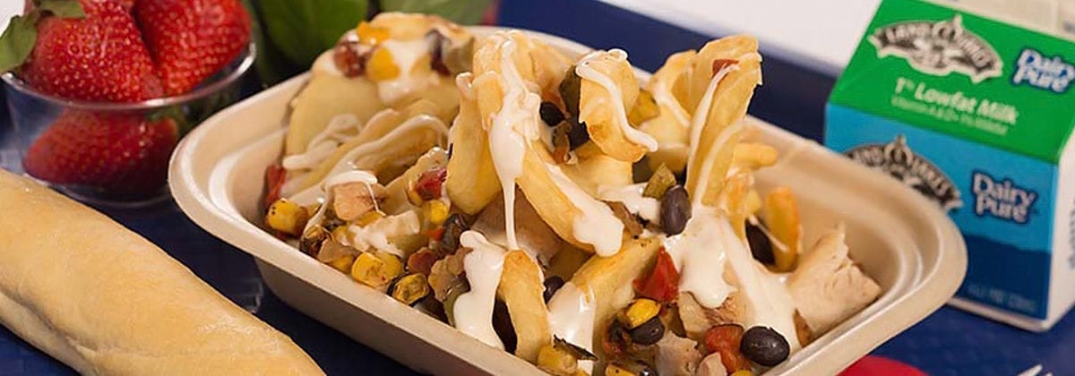 roasted nachos with strawberries and breadstick on school tray