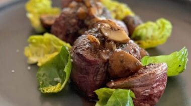 beef medalions with Brussels sprout leaves and mushrooms