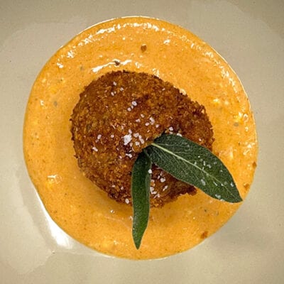 fried breaded food ball on orange sauce