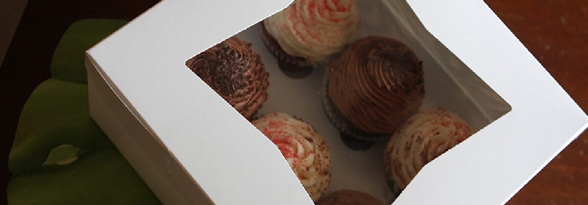 white bakery box holding cupcakes